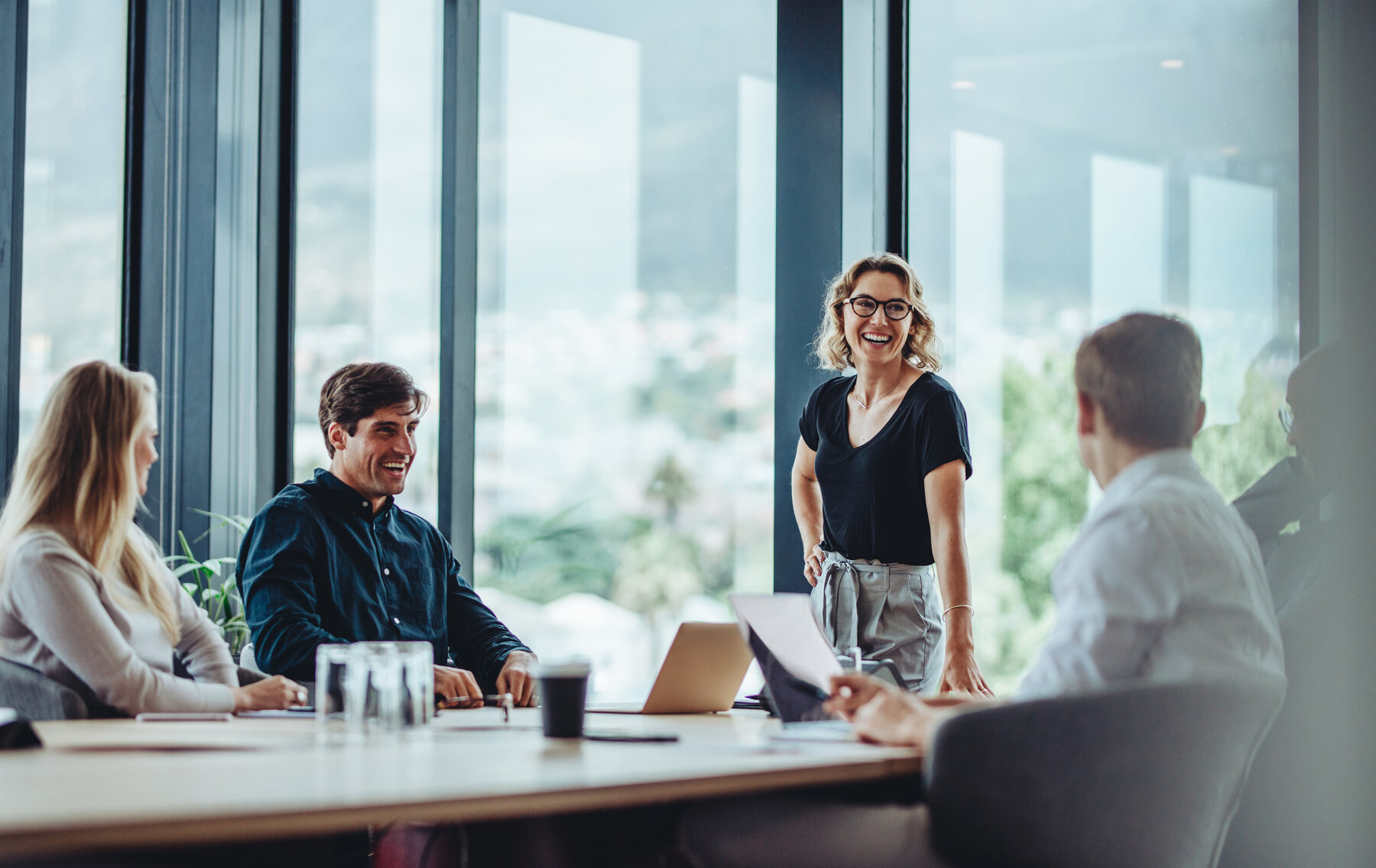 Real estate team owner presenting to her team in a modern office
